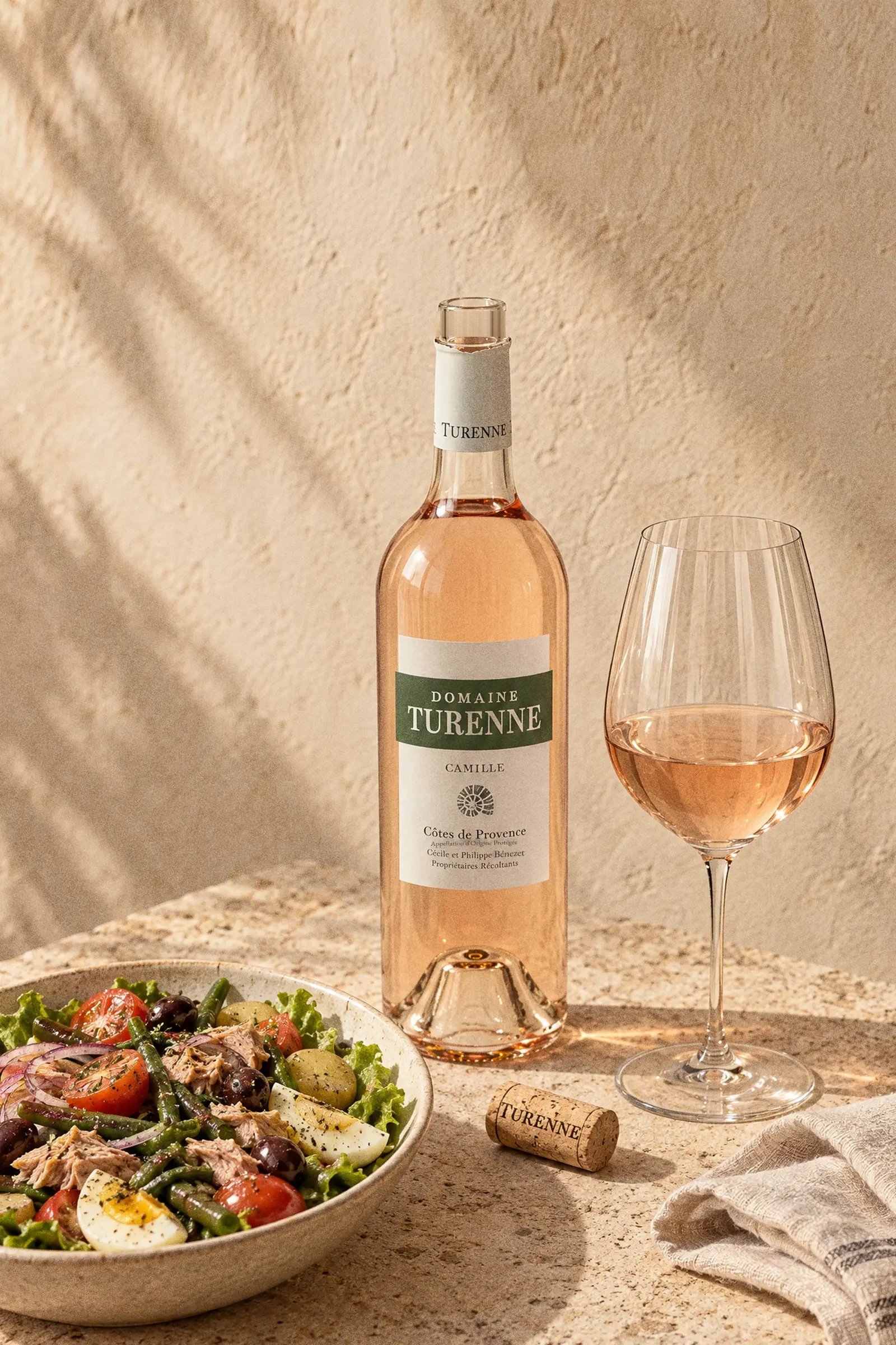 Domaine Turenne Camille Côtes de Provence Rosé 2025 open bottle with white TURENNE capsule, cork beside, glass and salad
